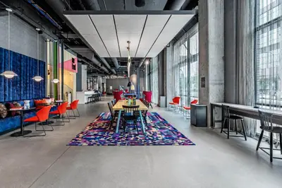 a large room with a table and chairs and windows at Aloft Columbus Easton in Columbus