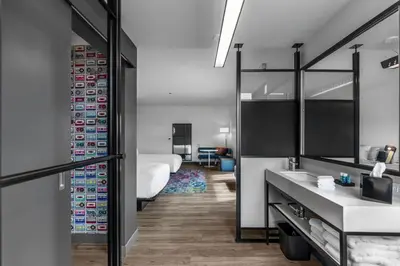 a bathroom with a bed and a sink and a mirror at Aloft Columbus Easton in Columbus