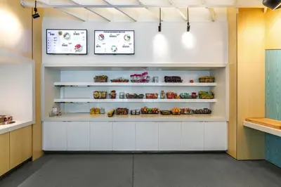 a kitchen with white cabinets and shelves with food at Aloft Columbus Easton in Columbus