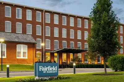 a brick building with a sign in front of it at Fairfield Inn & Suites Madison Historic Eagle Cotton Mill in Madison