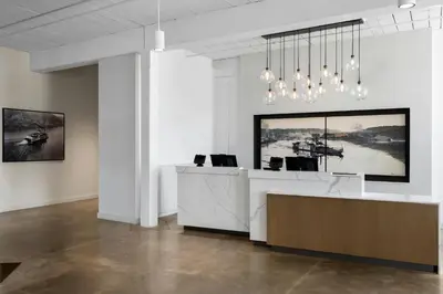 a white office with a reception desk and chandelier at Fairfield Inn & Suites Madison Historic Eagle Cotton Mill in Madison
