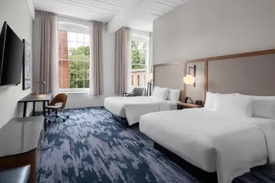 a hotel room with two beds and a television at Fairfield Inn & Suites Madison Historic Eagle Cotton Mill in Madison