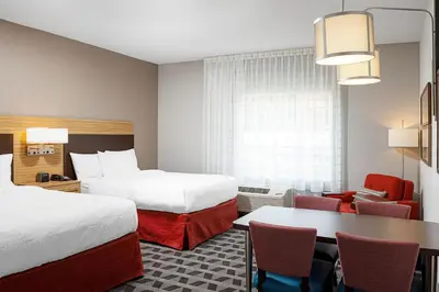 a hotel room with two beds and a table and chairs at TownePlace Suites by Marriott Ironton in Ironton
