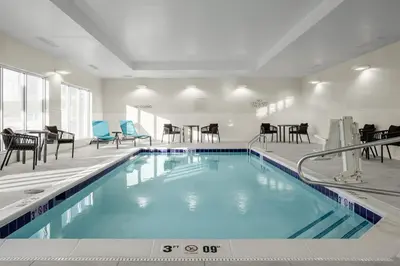 a pool in a hotel with chairs and tables at TownePlace Suites by Marriott Ironton in Ironton