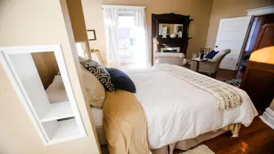 a bedroom with a white bed and a mirror at Chessie Room in Huntington