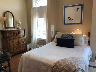 a bedroom with a bed and a dresser and a window at Chessie Room in Huntington