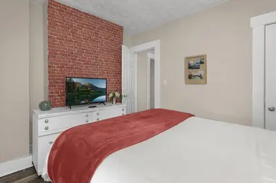a bedroom with a bed and a brick wall at Chic 2BR near DT, 8 min walk to Park&Conservatory in Columbus