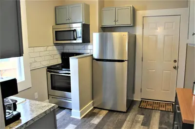 a kitchen with a stainless steel refrigerator and microwave at Modern 2BR near DT, 8min walk to Park&Conservatory in Columbus