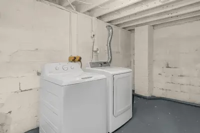 a white washing machine in a room with a wall at Modern 2BR near DT, 8min walk to Park&Conservatory in Columbus