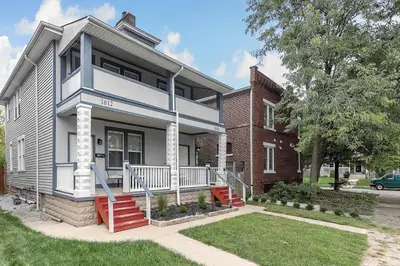 a white and blue house with a brick building at Modern 2BR near DT, 8min walk to Park&Conservatory in Columbus