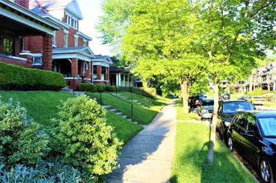 a house with cars parked on the side of a street at Modern 2BR near DT, 8min walk to Park&Conservatory in Columbus