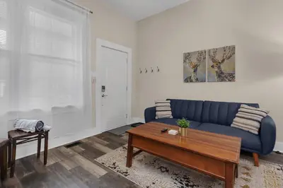 a living room with a blue couch and a table at Modern 2BR near DT, 8min walk to Park&Conservatory in Columbus
