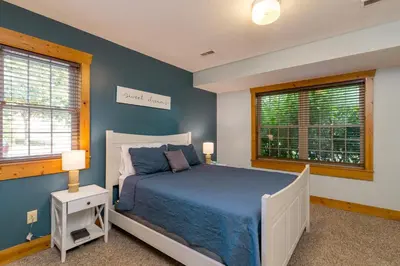 a bedroom with a bed and two windows at Canadian Hemlock . Trailside Lodging in Millersburg