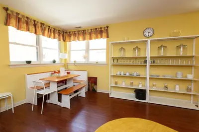 a dining room with a table and a clock on a shelf at Home STEPS from Oberlin in Oberlin