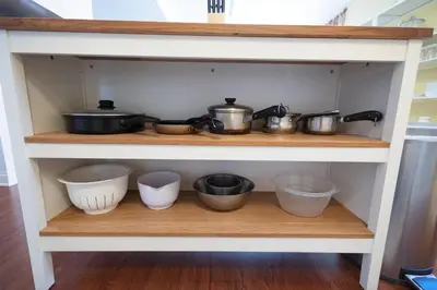 a shelf with pots and pans and other kitchen utensils at Home STEPS from Oberlin in Oberlin