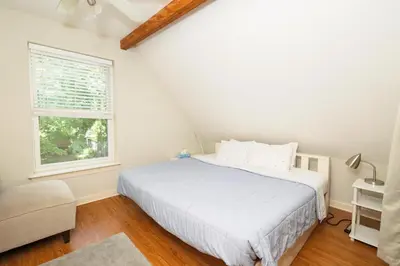 a bedroom with a white bed and a window at Home STEPS from Oberlin in Oberlin