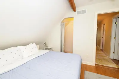a white bedroom with a bed and a hallway at Home STEPS from Oberlin in Oberlin