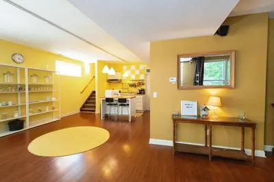 a living room with yellow walls and a wooden floor at Home STEPS from Oberlin in Oberlin