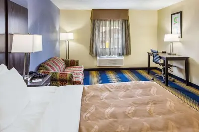 a hotel room with a bed and a desk at Quality Inn Charleston South in Charleston