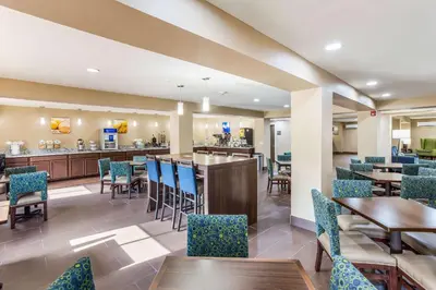 a restaurant with tables and chairs and a bar at Quality Inn Charleston South in Charleston