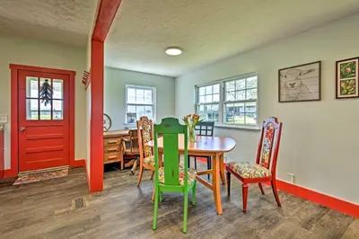 a dining room with a table and chairs and a red door at Renovated KY Farmhouse Retreat with Pasture Views! in Wallingford