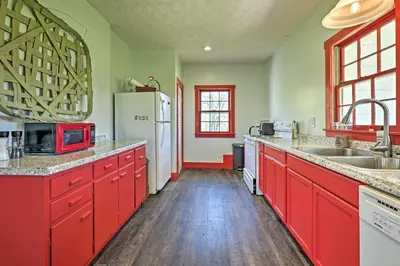 a kitchen with red cabinets and a white refrigerator at Renovated KY Farmhouse Retreat with Pasture Views! in Wallingford
