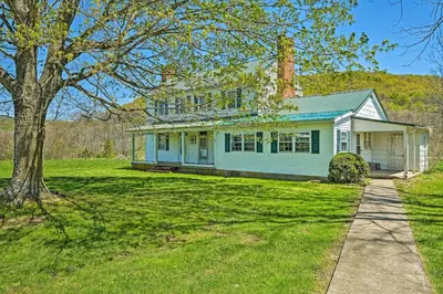 a white house with a tree in the yard at Renovated KY Farmhouse Retreat with Pasture Views! in Wallingford