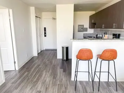 a kitchen with two orange chairs at a counter at Sleepover Downtown Cincinnati 1BD 1BA Apartments in Cincinnati