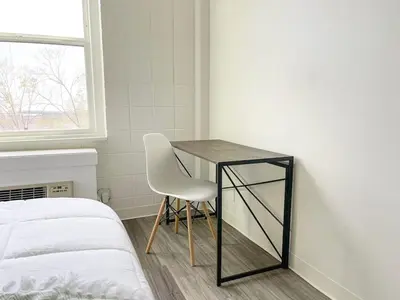a bedroom with a table and a chair next to a bed at Sleepover Downtown Cincinnati 1BD 1BA Apartments in Cincinnati