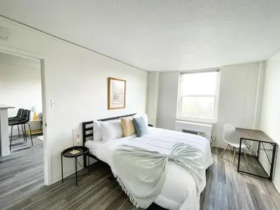 a white bedroom with a large bed and a table at Sleepover Downtown Cincinnati 1BD 1BA Apartments in Cincinnati