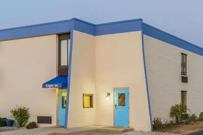 a large white building with a blue door at Knights Inn Dayton by Miller Lane in Dayton