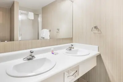 a white bathroom with two sinks and a mirror at Knights Inn Dayton by Miller Lane in Dayton