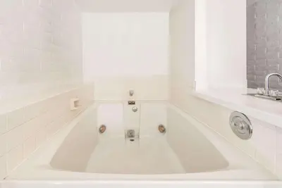 a white bath tub in a bathroom with a sink at Knights Inn Dayton by Miller Lane in Dayton