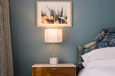 a bedroom with a bed and a lamp on a nightstand at The Bradley in Fort Wayne
