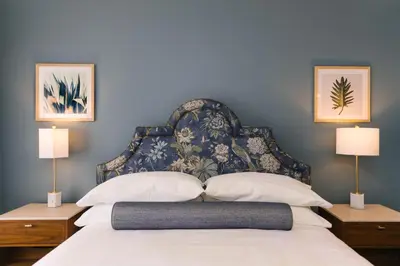 a bedroom with a bed with a blue wall at The Bradley in Fort Wayne