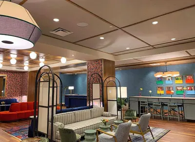 a lobby with a couch and chairs and a bar at The Bradley in Fort Wayne