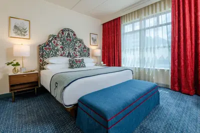 a bedroom with a bed and a window with red curtains at The Bradley in Fort Wayne