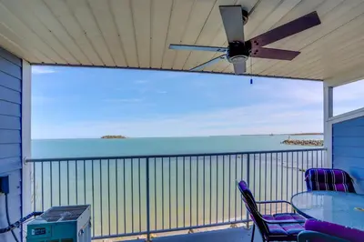 a screened in porch with a ceiling fan and chairs at Cozy Middle Bass Island Getaway On Lake Eerie! in Put-in-Bay