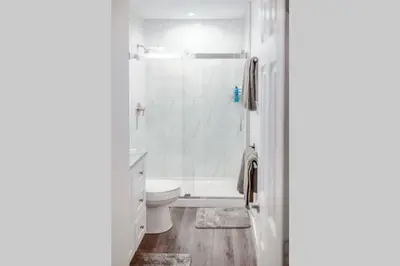 a white bathroom with a shower and a toilet at Newly Renovated(6A) OSU/ExpoCenter Near EVERYTHING! in Columbus