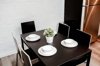 a black table with white plates and flowers on it at Newly Renovated(6A) OSU/ExpoCenter Near EVERYTHING! in Columbus