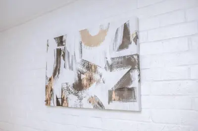 a painting hanging on a white brick wall at Newly Renovated(6A) OSU/ExpoCenter Near EVERYTHING! in Columbus