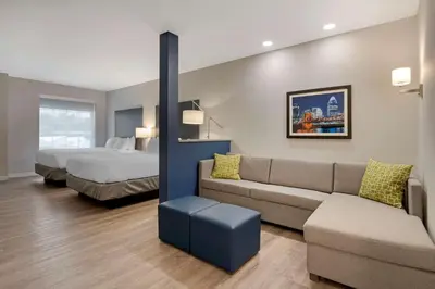 a hotel room with a couch and a bed at Comfort Suites Cincinnati University - Downtown in Cincinnati