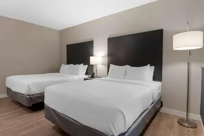 a hotel room with two beds and a lamp at Comfort Suites Cincinnati University - Downtown in Cincinnati