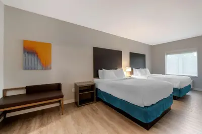a hotel room with two beds and a table at MainStay Suites Cincinnati University - Uptown in Cincinnati