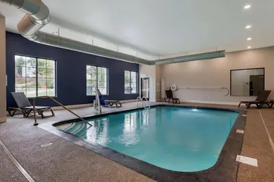 a large swimming pool in a room with chairs at MainStay Suites Cincinnati University - Uptown in Cincinnati