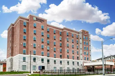 a large red brick building on a city street at MainStay Suites Cincinnati University - Uptown in Cincinnati