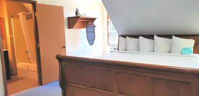 a bedroom with a bed with a wooden headboard at Berlin Heritage Inn in Berlin