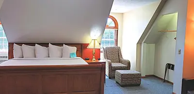 a bedroom with a bed with a lamp and a chair at Berlin Heritage Inn in Berlin