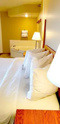 a bedroom with a bed with white sheets and a lamp at Berlin Heritage Inn in Berlin