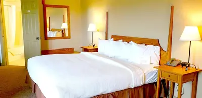 a large bed in a hotel room with a telephone at Berlin Heritage Inn in Berlin